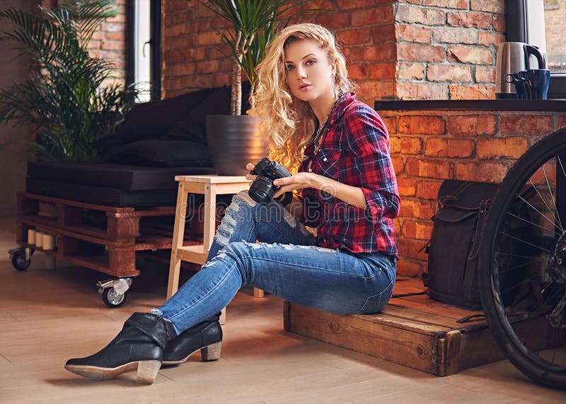 Amateur Blonde Female Photographe Taking Pictures in a Room with Stock Photo