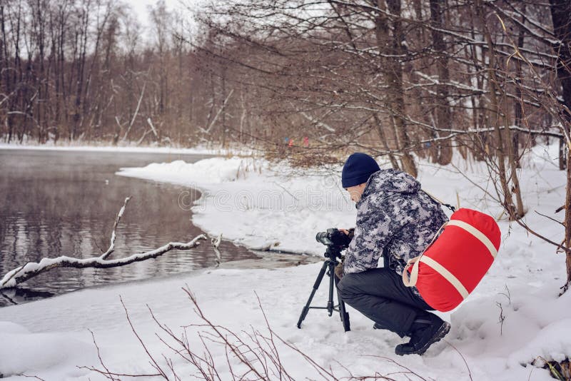 Amateurphotograph nimmt eine Winterlandschaft auf dem See im Waldkopienraum lizenzfreie stockbilder Amateurphotograph nimmt eine Winterlandschaft auf dem See im Waldkopienraum lizenzfreie stockbilder