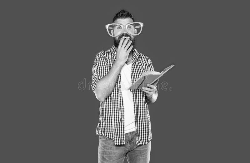 Amazed funny bearded man in party glasses read book royalty free stock images