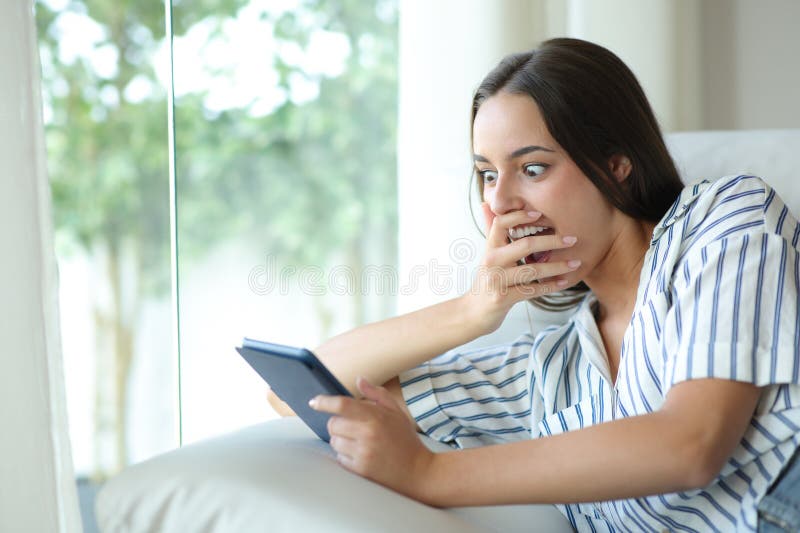 Amazed woman reading ebook after surprising plot twist stock images