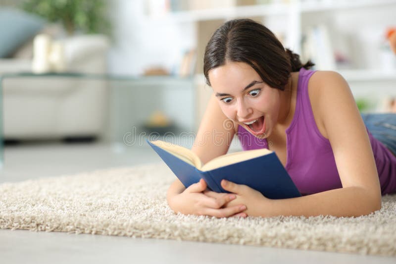 Amazed woman reading a paper book on a carpet royalty free stock images