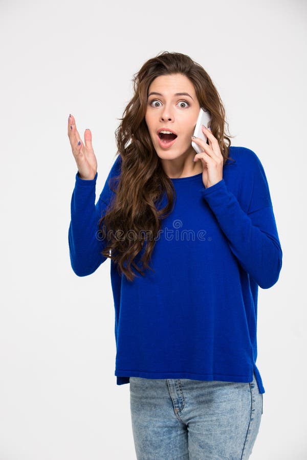 Amazed woman talking on the phone stock photography