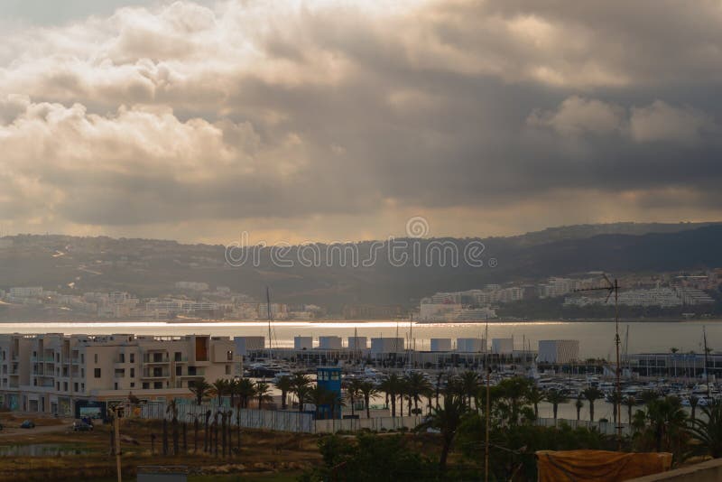 Amazing beautiful panoramic view of marina, on which small storm is approaching. Sun rays, beams passing through layers royalty free stock photos
