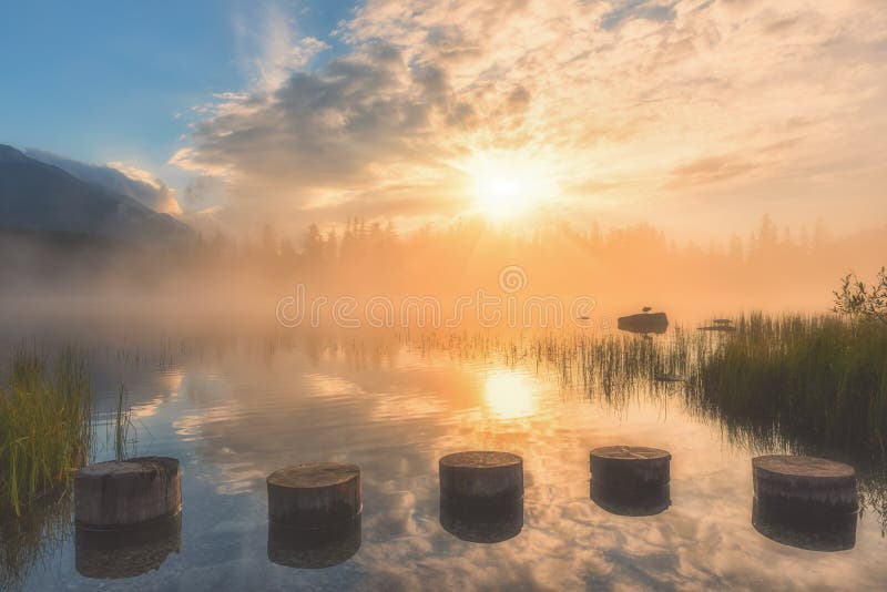 Úžasný hmlový východ slnka pri alpskom jazere Štrbské pleso, slnečná krajina v mäkkom svetle, vysoké tatry, slovensko