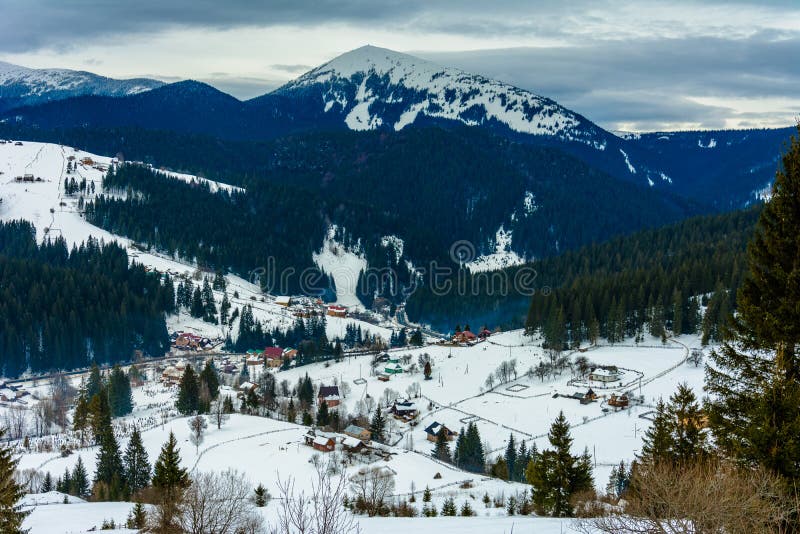 Úžasná krajina ukrajinskej horskej dediny v Karpatoch v zime za úsvitu