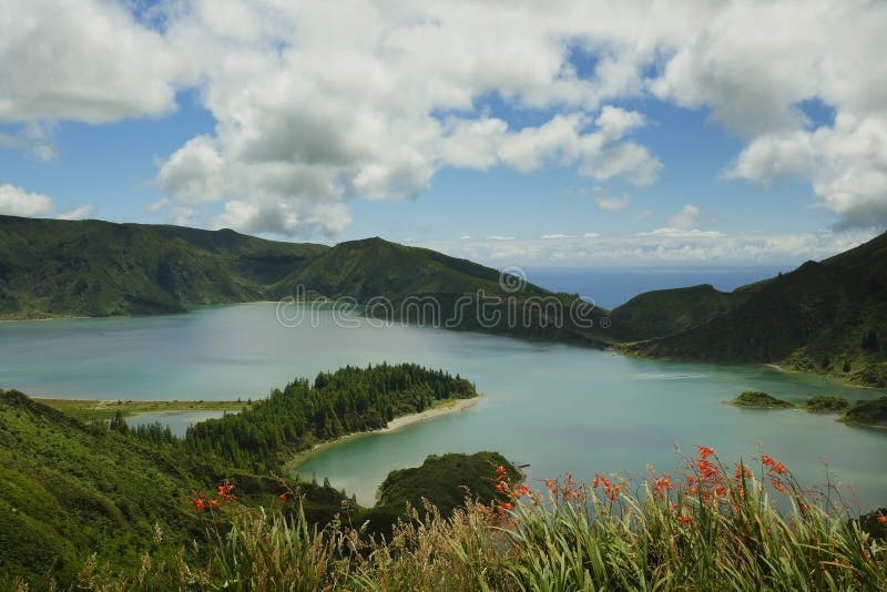 amazing landscape view of crater volcano lake in Sao Miguel island of Azores Portugal with flowers beautiful turquoise water