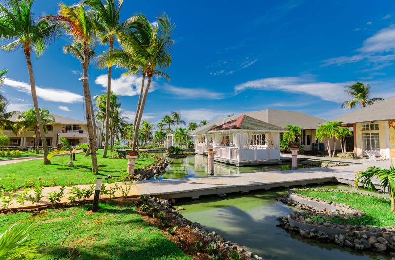 Amazing natural landscape view of resort grounds and restaurant buildings, in tropical garden surrounded by water on sunny gorgeou