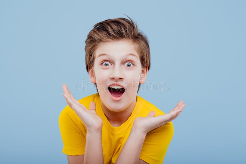 Amazing preteen boy looks at camera in yellow t-shirt