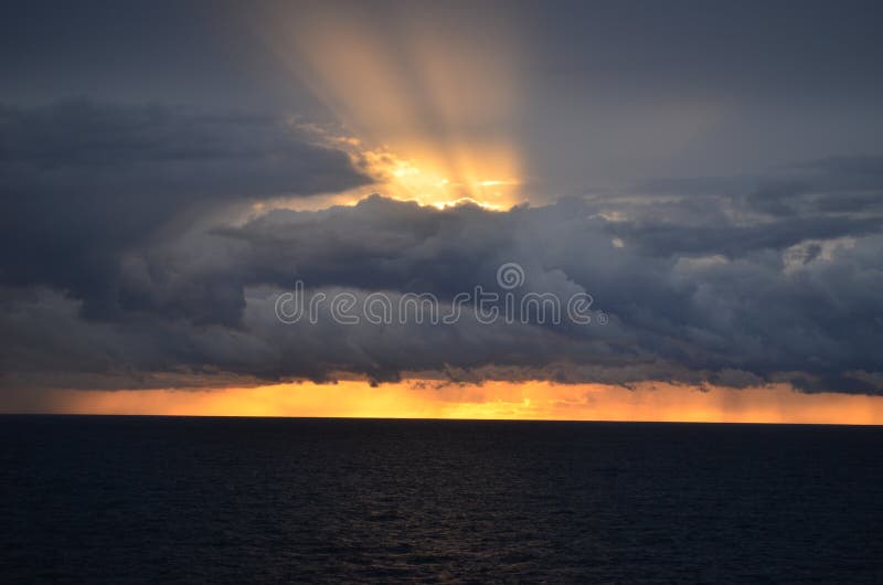 Amazing sunset with long rays piercing the clouds royalty free stock images