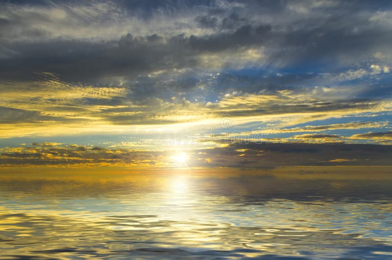 Amazing view of the sun, filtering through the dark clouds over the quiet surface of the ocean. Amazing view scene stock images, royalty-free photos and pictures