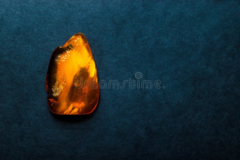 Amber Stone on Dark Blue Background Surface With Free Space stock photo