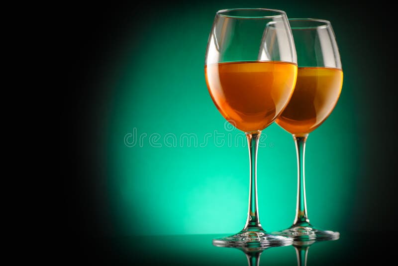 Amber wine in a glass. Traditional Georgian wine according to ancient technology. Colored green gradient background. Сopy space. Close up and horizontal royalty free stock image Amber wine in a glass. Traditional Georgian wine according to ancient technology. Colored green gradient background. Сopy space. Close up and horizontal royalty free stock image