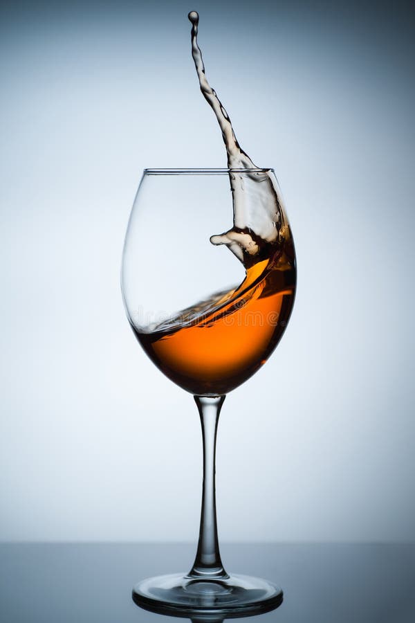 Amber wine. A splash of wine in a glass. Liquid in a glass. Traditional wine according to the ancient Georgian technology. Concept with a glass of wine. Copy royalty free stock images Amber wine. A splash of wine in a glass. Liquid in a glass. Traditional wine according to the ancient Georgian technology. Concept with a glass of wine. Copy royalty free stock images