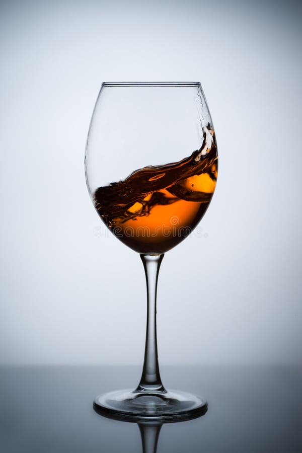 Amber wine. A splash of wine in a glass. Liquid in a glass. Traditional wine according to the ancient Georgian technology. Concept with a glass of wine. Copy royalty free stock photography Amber wine. A splash of wine in a glass. Liquid in a glass. Traditional wine according to the ancient Georgian technology. Concept with a glass of wine. Copy royalty free stock photography
