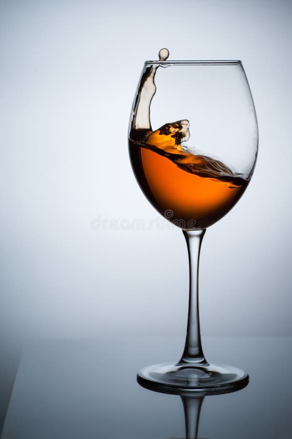 Amber wine. Wine in a glass. Amber wine. A splash of wine in a glass. Liquid in a glass. Traditional wine according to the ancient Georgian technology. Concept royalty free stock photography Amber wine. Wine in a glass. Amber wine. A splash of wine in a glass. Liquid in a glass. Traditional wine according to the ancient Georgian technology. Concept royalty free stock photography