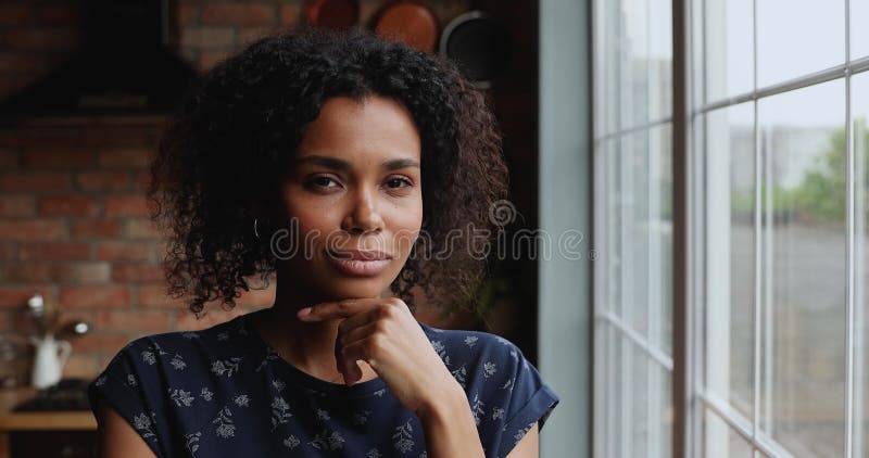 Ambitieuse femme africaine penser puis se tourner vers la caméra avec le sourire clips vidéos