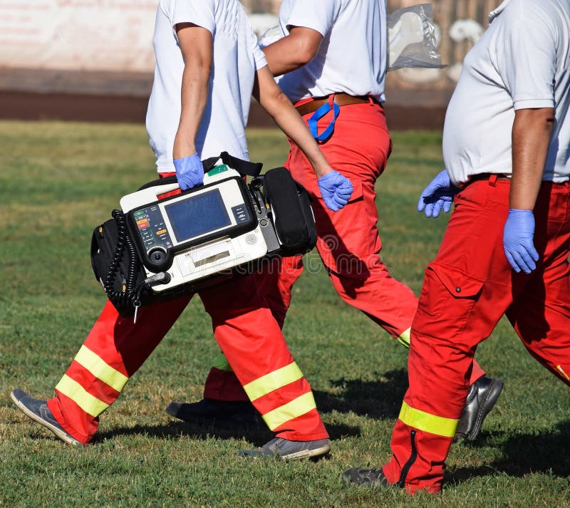 Ambulance Staff with Medical Equipment on a Sport Track Stock Photo