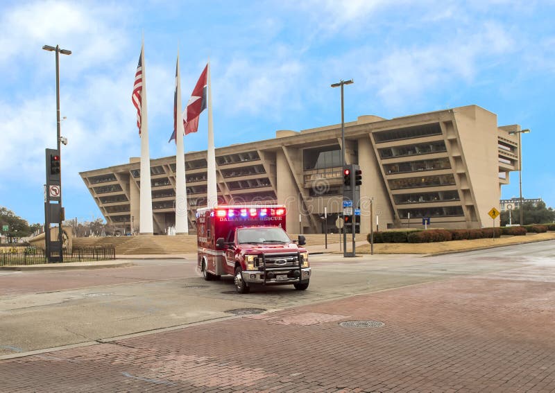Ambulancia delante de Dallas City Hall con el americano, Tejas, y la ciudad de Dallas Flags imagen de archivo libre de regalías Ambulancia delante de Dallas City Hall con el americano, Tejas, y la ciudad de Dallas Flags imagen de archivo libre de regalías