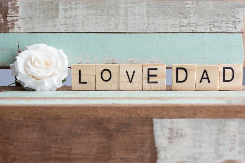 Ame las palabras del papá con la rosa del blanco en la tabla rústica del vintage imagen de archivo libre de regalías Ame las palabras del papá con la rosa del blanco en la tabla rústica del vintage imagen de archivo libre de regalías