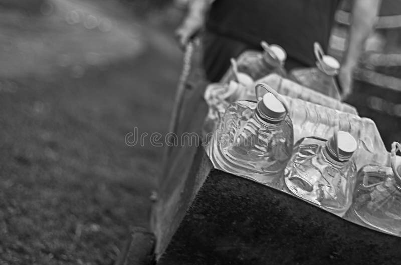 Amenazas de la escasez del cambio de clima y del abastecimiento de agua El varón blanco tira de un carro de las botellas plástica foto de archivo Amenazas de la escasez del cambio de clima y del abastecimiento de agua El varón blanco tira de un carro de las botellas plástica foto de archivo