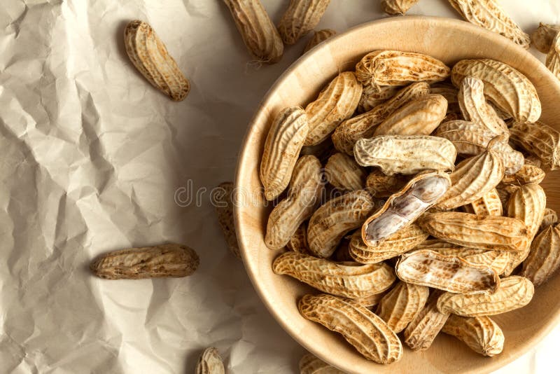 the boiled peanuts in wooden cup on crumpled paper. the boiled peanuts in wooden cup on crumpled paper