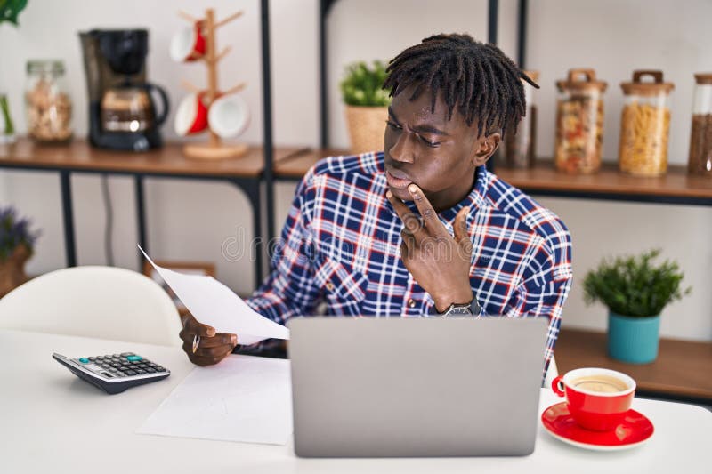 American african care utilizează un laptop care citește documente la domiciliu stock photography