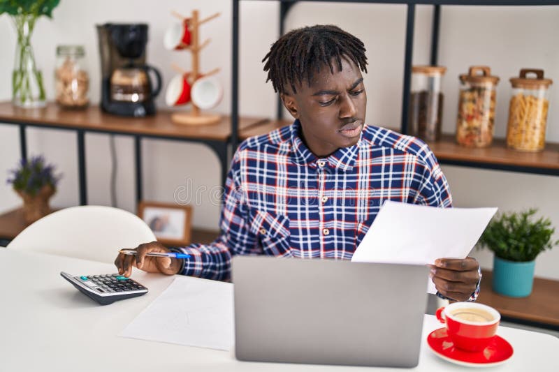 American african care utilizează un laptop care citește documente la domiciliu stock images