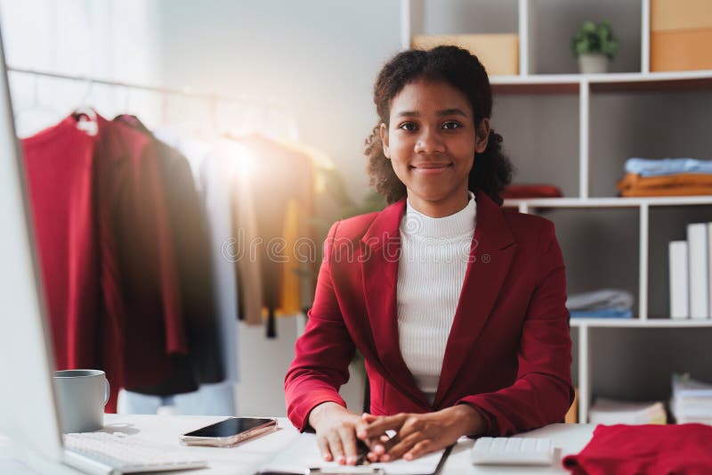 American African Fashion Designer Working in Studio with Laptop