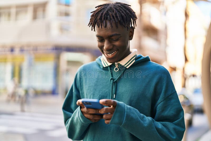 American african zâmbind încrezător folosind smartphone-ul pe stradă royalty free stock photography