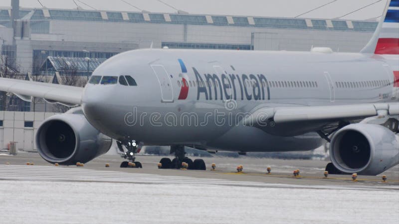 American Airlines som gör taxien i den Munich flygplatsen, snö