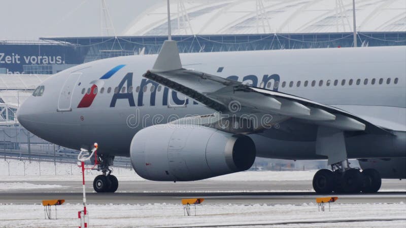 American Airlines som tar av från den Munich flygplatsen, snö