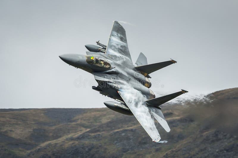 United States Air Force USAF F15 military fighter jet aircraft against British mountain backdrop whilst on a low level training mission. United States Air Force USAF F15 military fighter jet aircraft against British mountain backdrop whilst on a low level training mission.