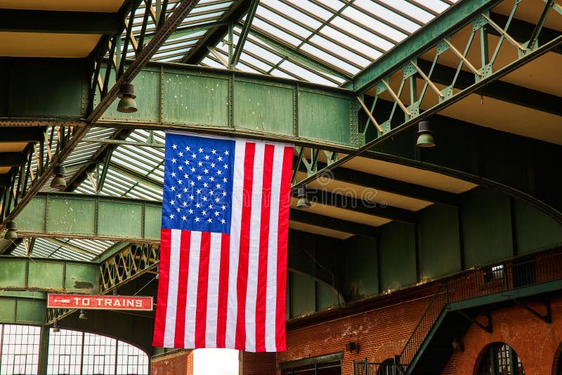American Flag Hangs from Steel Open Ceiling in Train Station of New