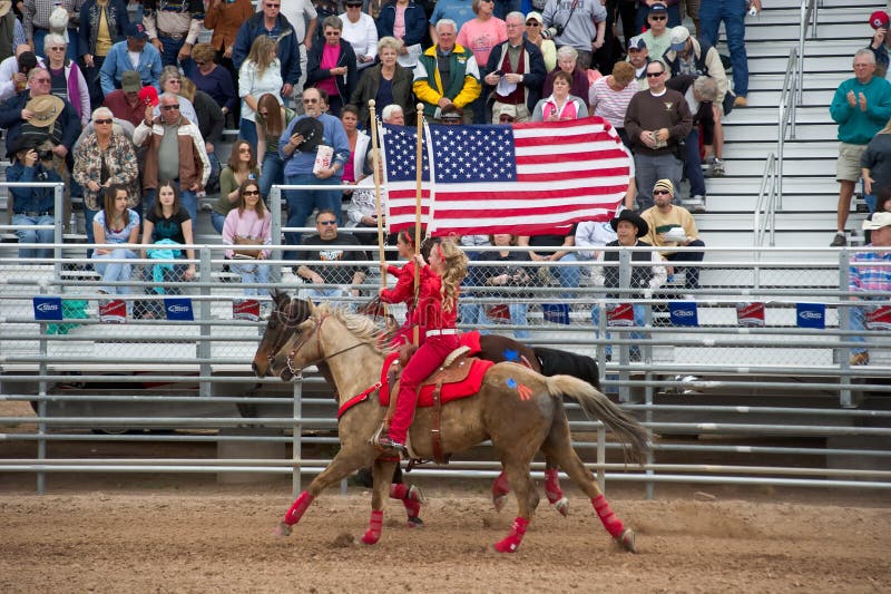 APACHE JUNCTION, AZ - FEBRUARY 27: Two girls on horseback display the American flag at the Lost Dutchman Days rodeo on February 27, 2010 in Apache Junction, Arizona. APACHE JUNCTION, AZ - FEBRUARY 27: Two girls on horseback display the American flag at the Lost Dutchman Days rodeo on February 27, 2010 in Apache Junction, Arizona.