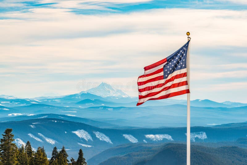 American flag over the peak of snow mountain
