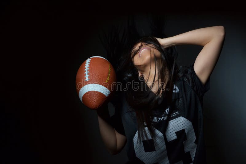 Beautiful young woman, american football concept, studio shot