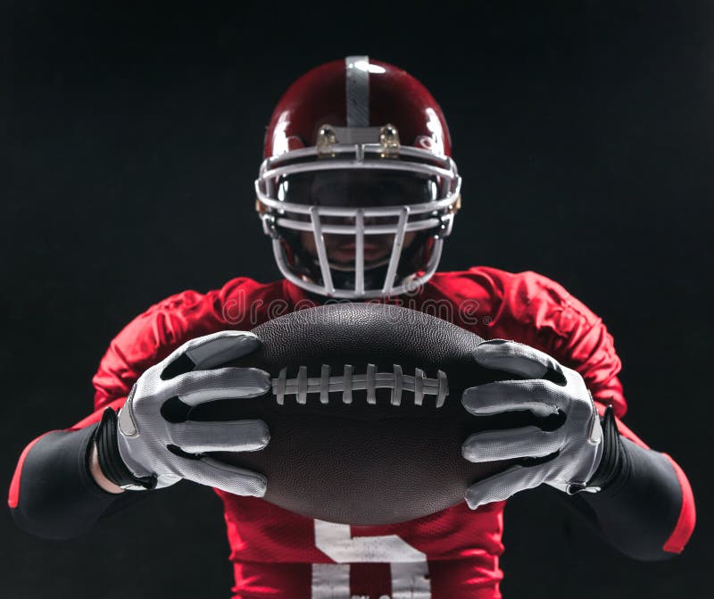 American football player posing with ball on black background royalty free stock photo American football player posing with ball on black background royalty free stock photo