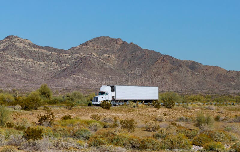 American make big rig semi truck transporting reefer fast on mountain highway