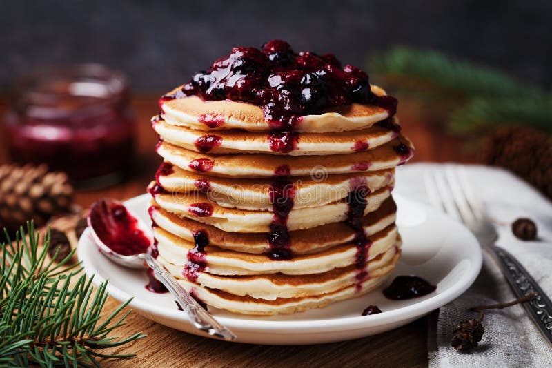 Americké palacinky alebo lievance, podávané s jahody a čučoriedky jam, lahodný dezert na raňajky v zime, rustikálny štýl.