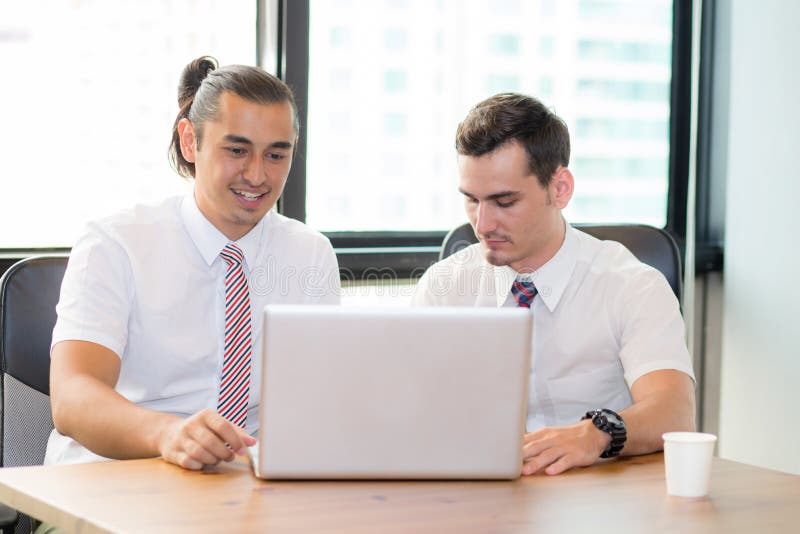 American people business two young caucasian modern man sitting in a meeting room using and looking laptop together. royalty free stock photos American people business two young caucasian modern man sitting in a meeting room using and looking laptop together. royalty free stock photos
