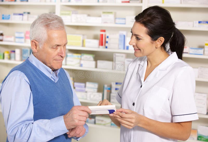 American pharmacist serving senior man in pharmacy