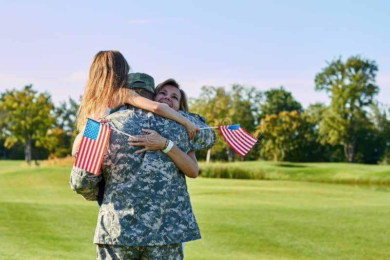 American soldier reunited with his family in park. royalty free stock photo American soldier reunited with his family in park. royalty free stock photo