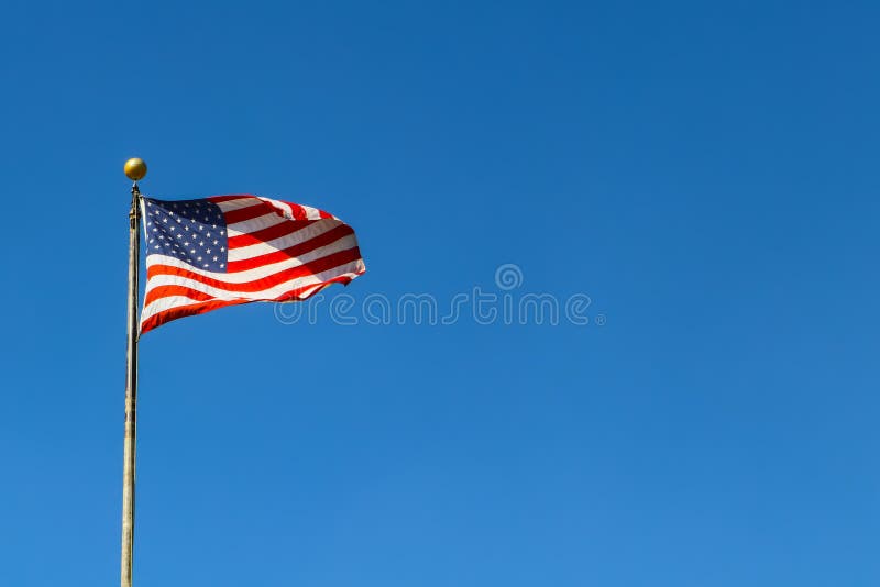 Amerikaanse Vlag die tegen zeer blauwe hemel op vlaggestok golven - ruimte voor exemplaar