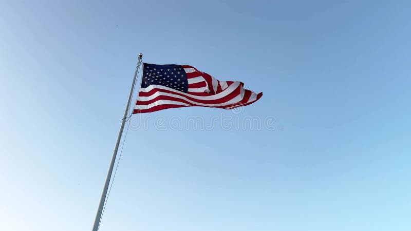 Amerikaanse vlag zwaait in de wind met een blauwe achtergrond