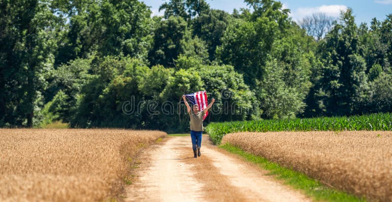 Amerikanische Flagge und Großbauer. Flagge der USA. Unabhängigkeitstag. Mann auf dem Feld. Mann mit amerikanischer Flagge auf dem lizenzfreie stockbilder