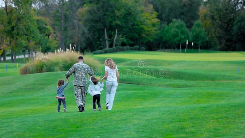 Amerikanischer Soldat mit seinem glücklichen familiy, Spaß in der Parkwiese habend