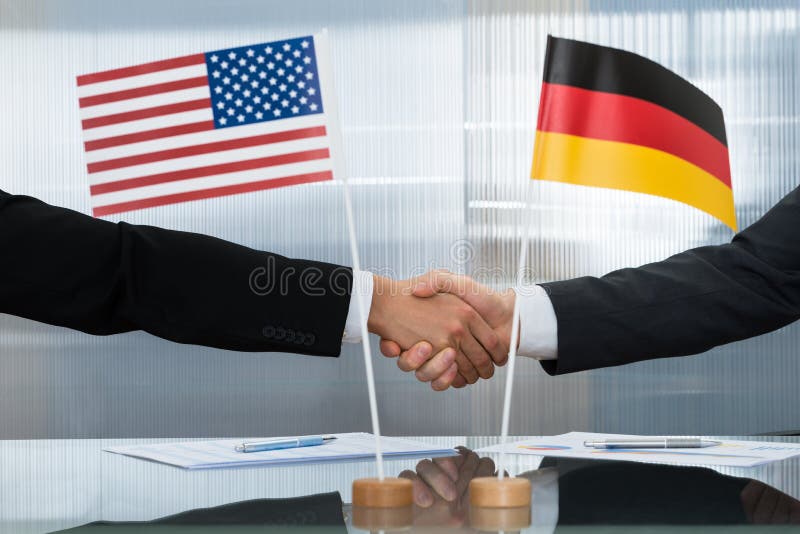 Amerikanischer und deutscher Geschäftsmann, der Hände rüttelt lizenzfreie stockbilder Amerikanischer und deutscher Geschäftsmann, der Hände rüttelt lizenzfreie stockbilder