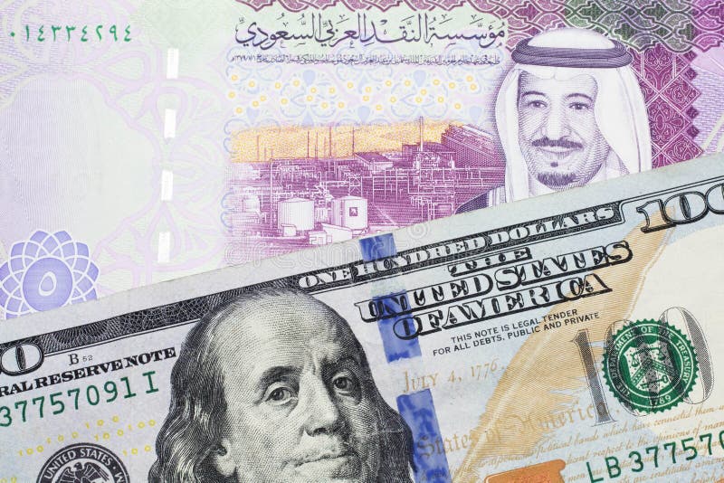 Amerikansk 100-dollarsedel med en färgstark 5-riyalsedel från saudi arabia arkivfoto