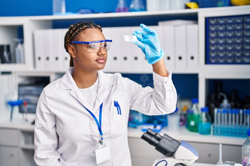 Amerikanska kvinnliga forskare som tittar på prover på laboratoriet arkivfoto