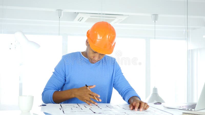 Amerykanina Architektoniczny inżynier Pracuje na projekcie w Jego biurze obraz stock Amerykanina Architektoniczny inżynier Pracuje na projekcie w Jego biurze obraz stock